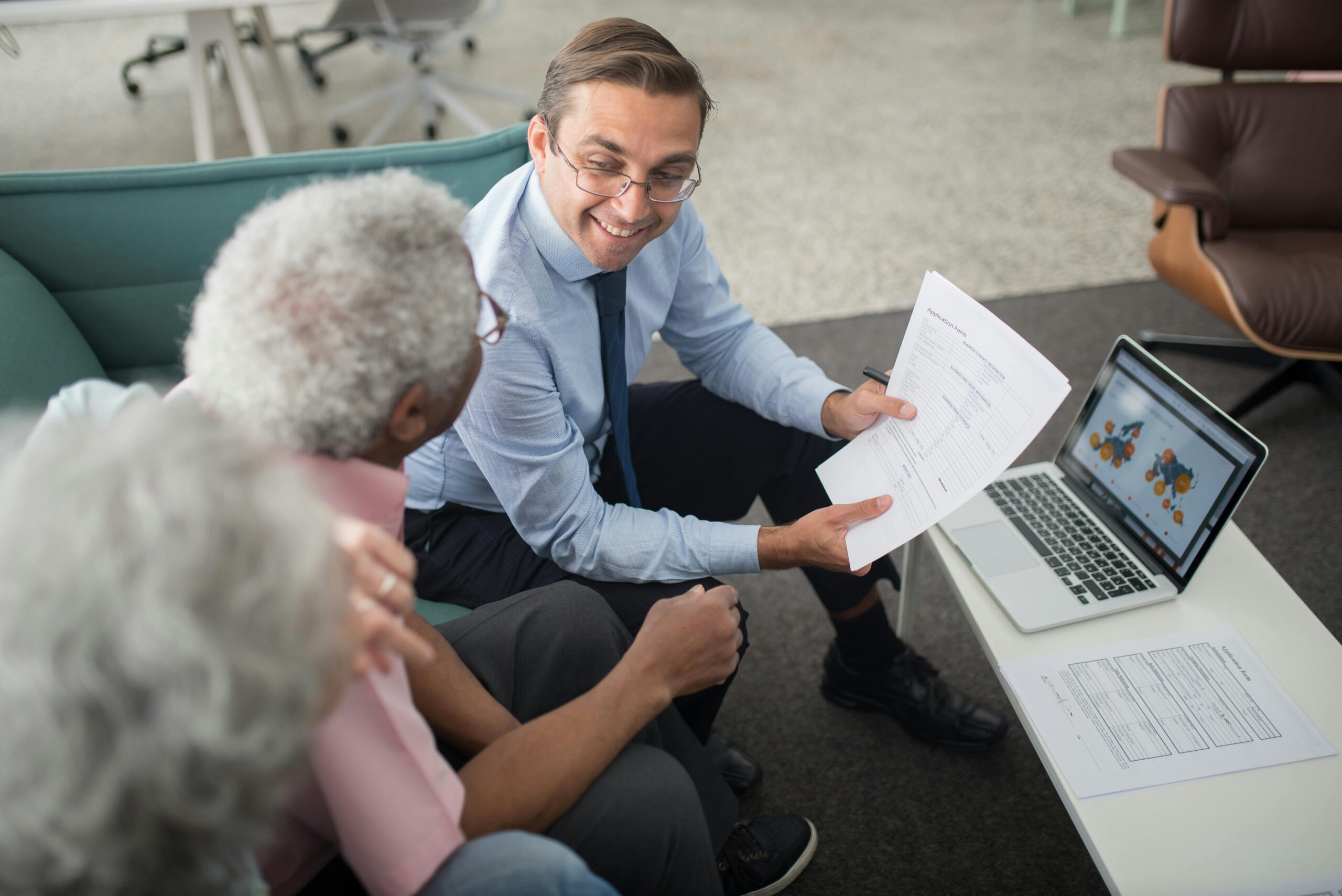 A sales professional showing documents to two clients